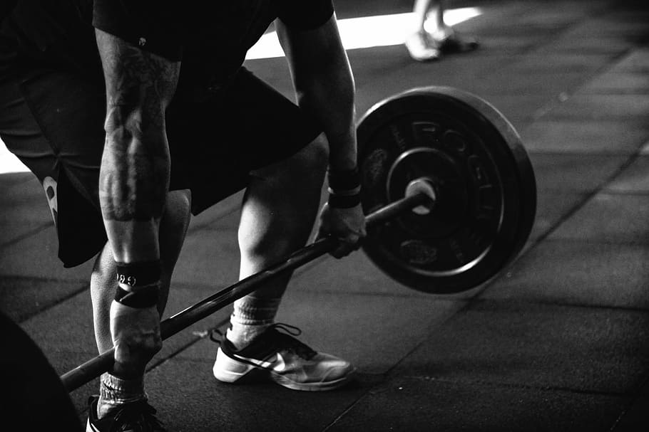 Black and white picture: man lifting a barbell